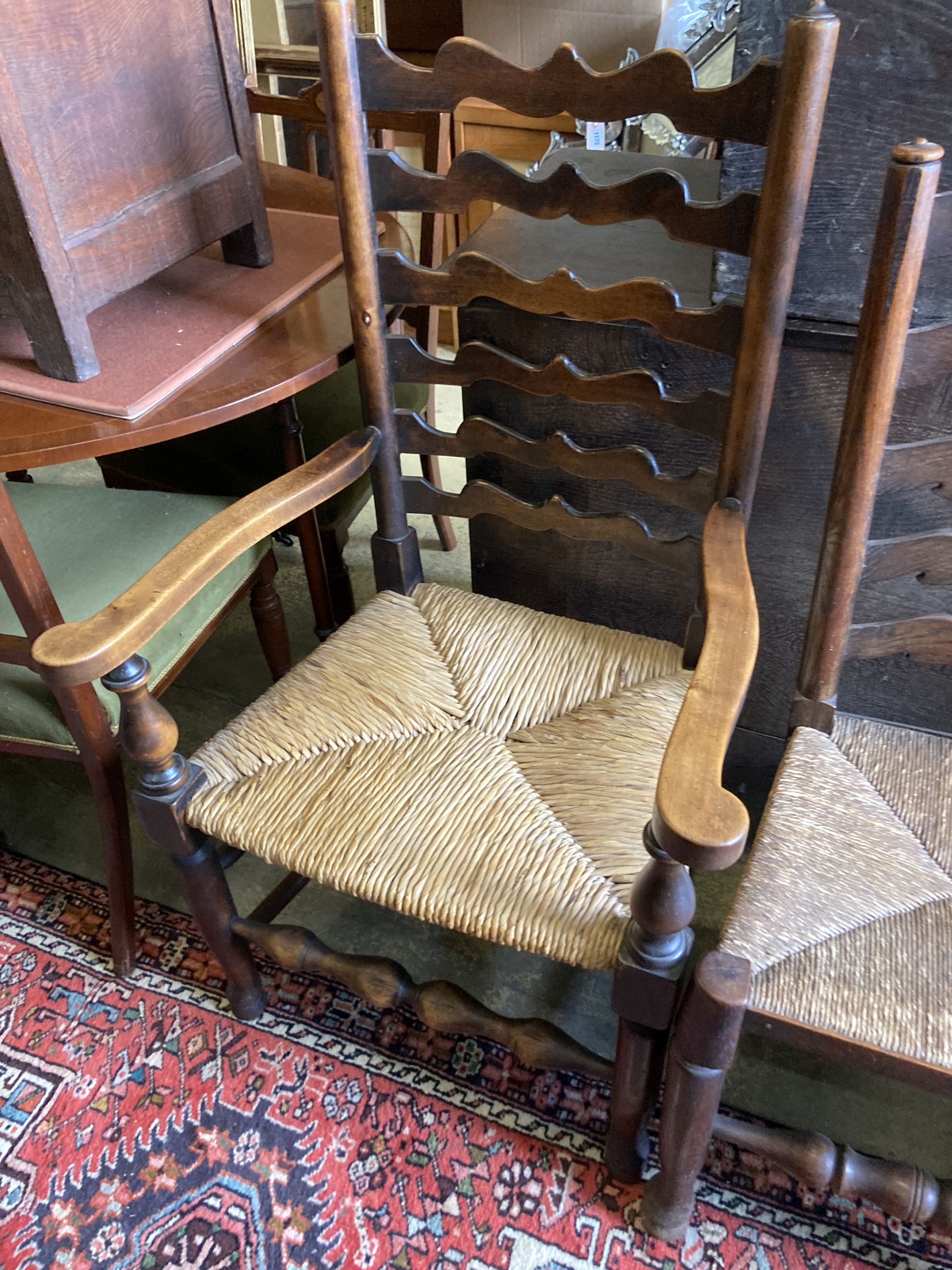 A harlequin set of seven oak and beech rush seated, ladder back dining chairs